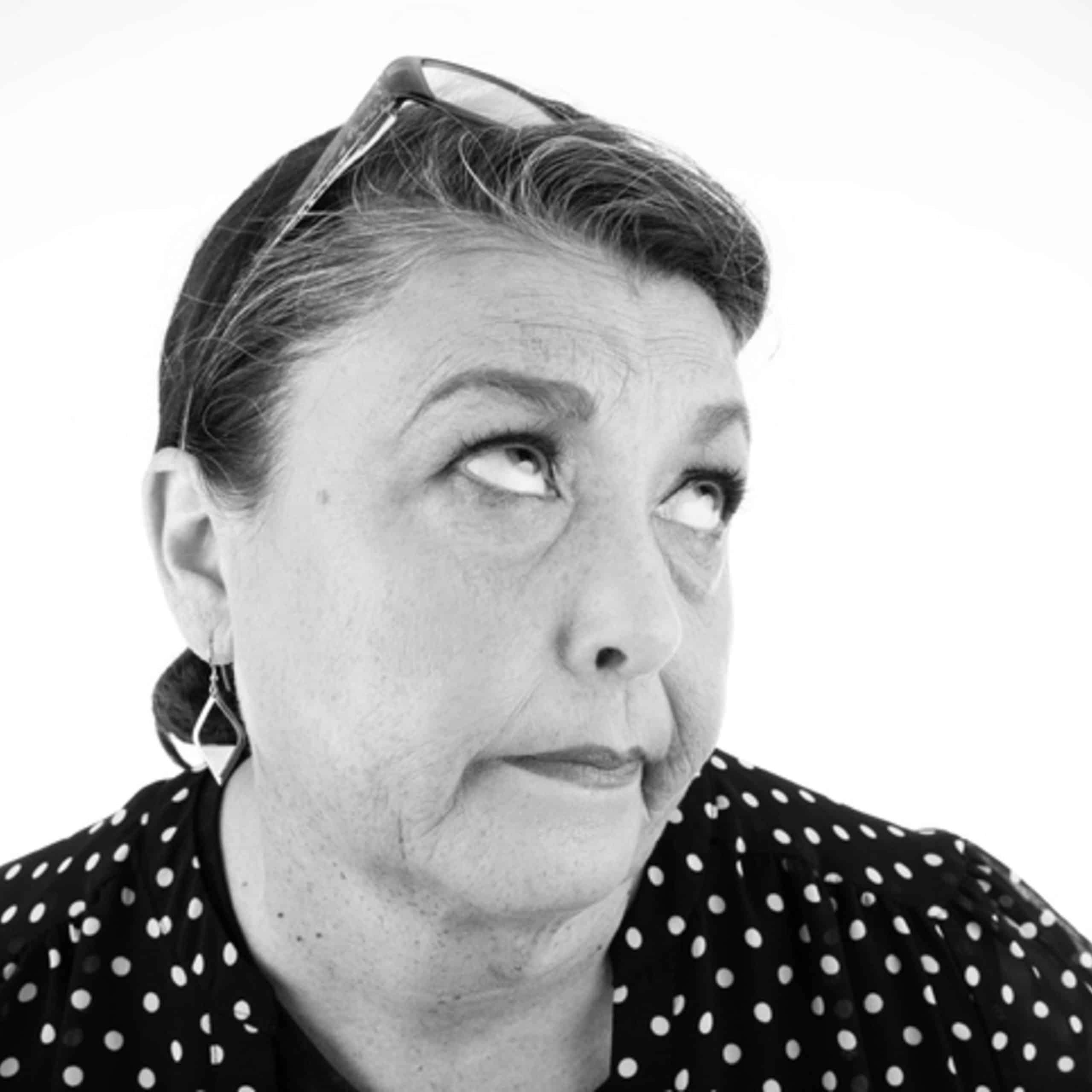 A black and white photo of a woman looking up.