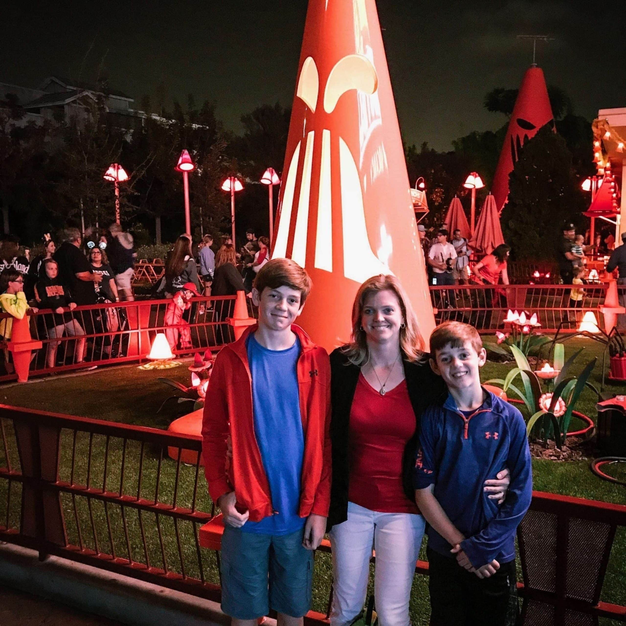 A family posing for a photo in front of a red cone.