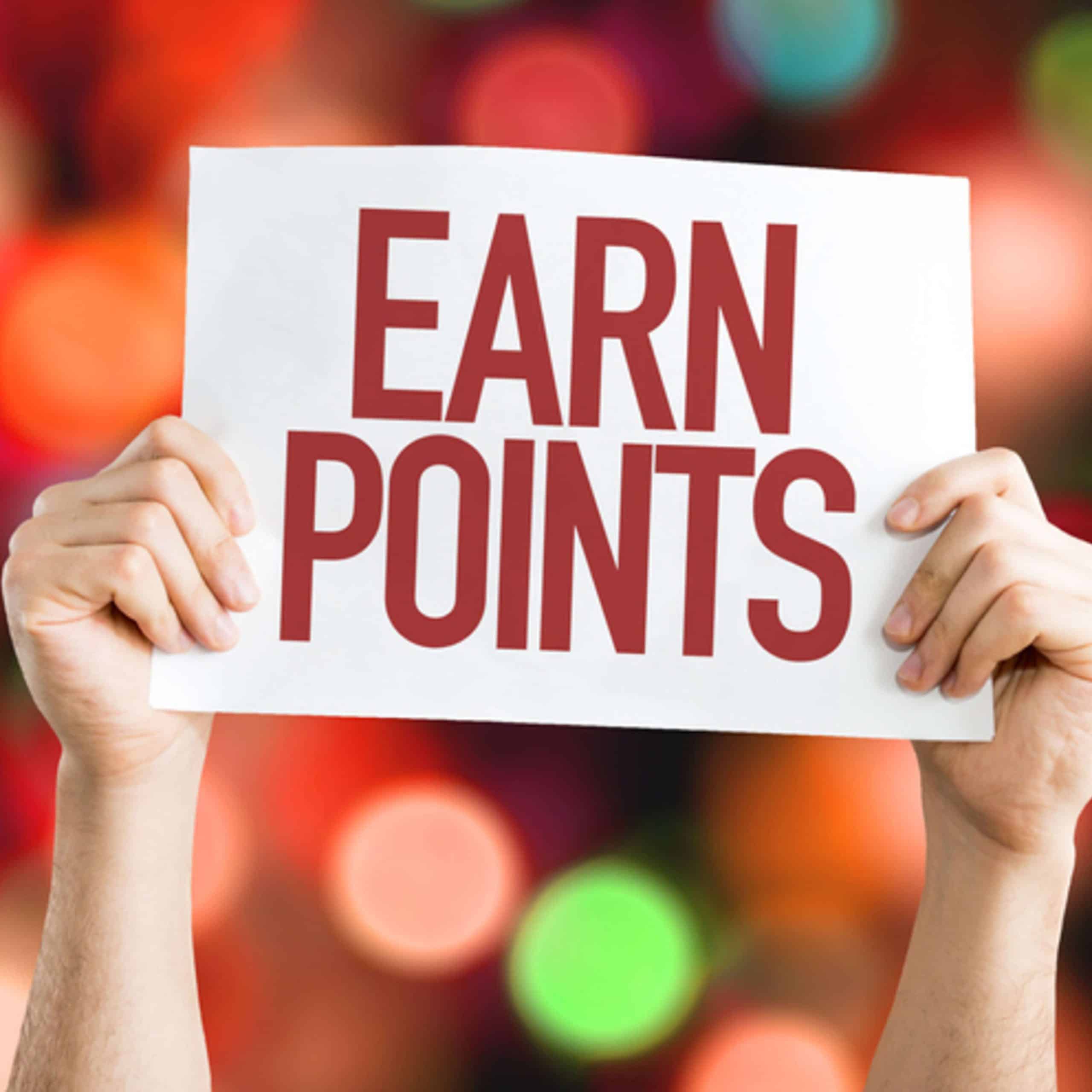 A man holding up a sign that says earn points.