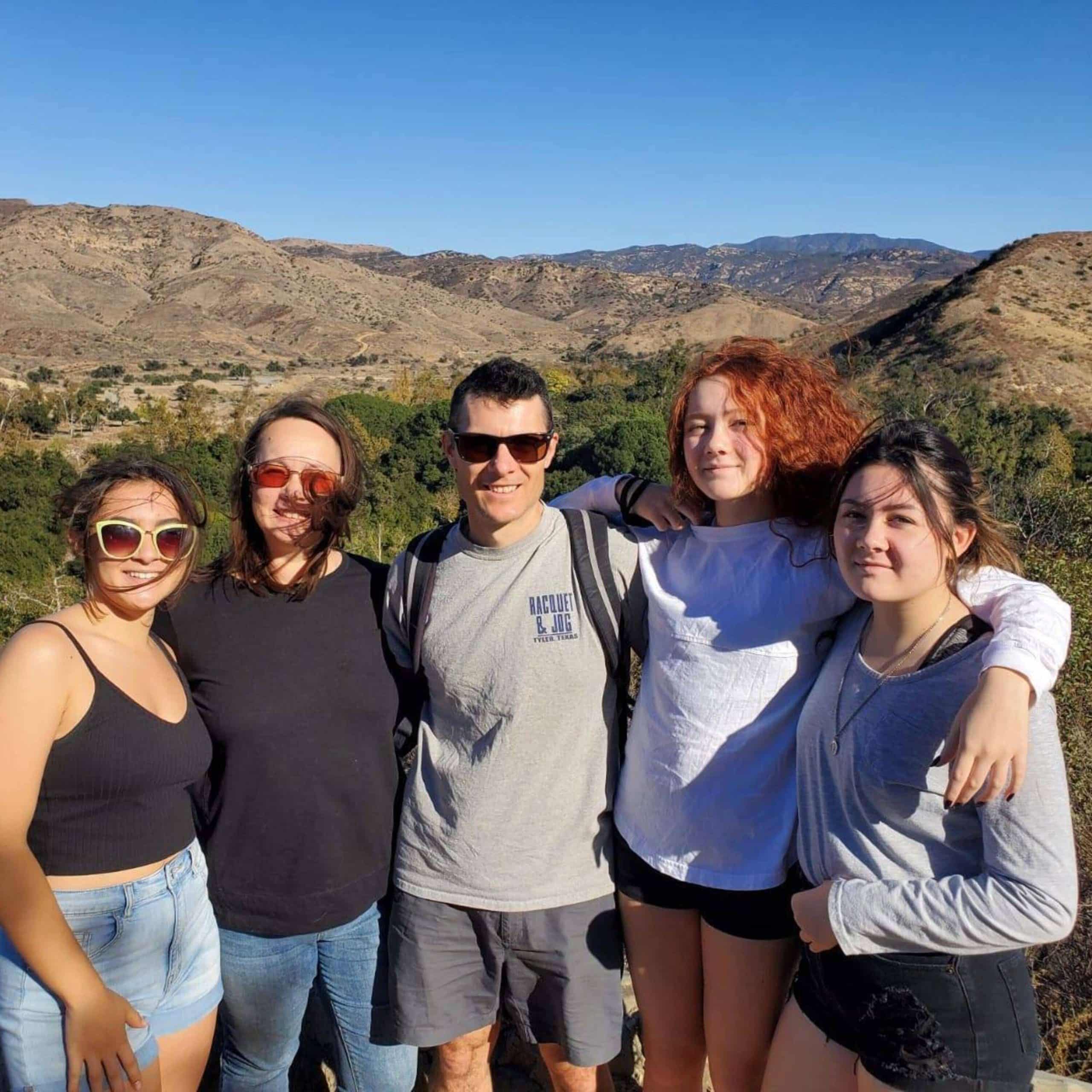 A group of people posing for a photo in the mountains.