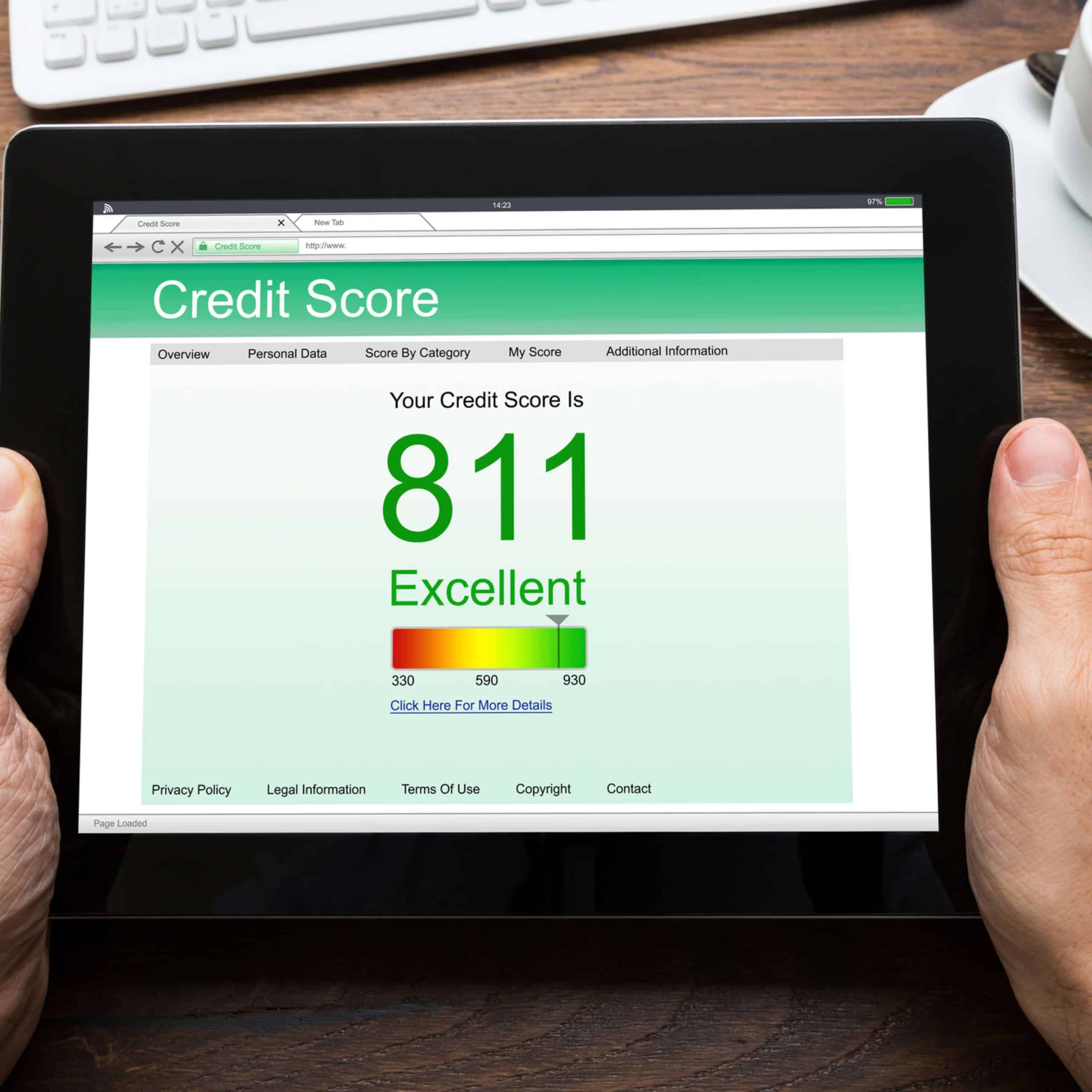 A person holding a tablet with a credit score displayed on it.