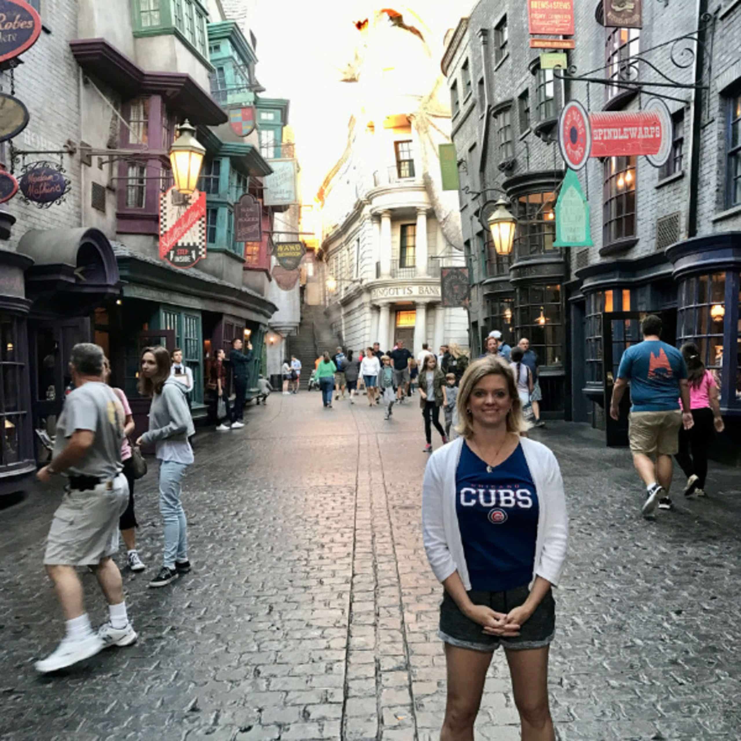 A woman standing in front of a harry potter street.