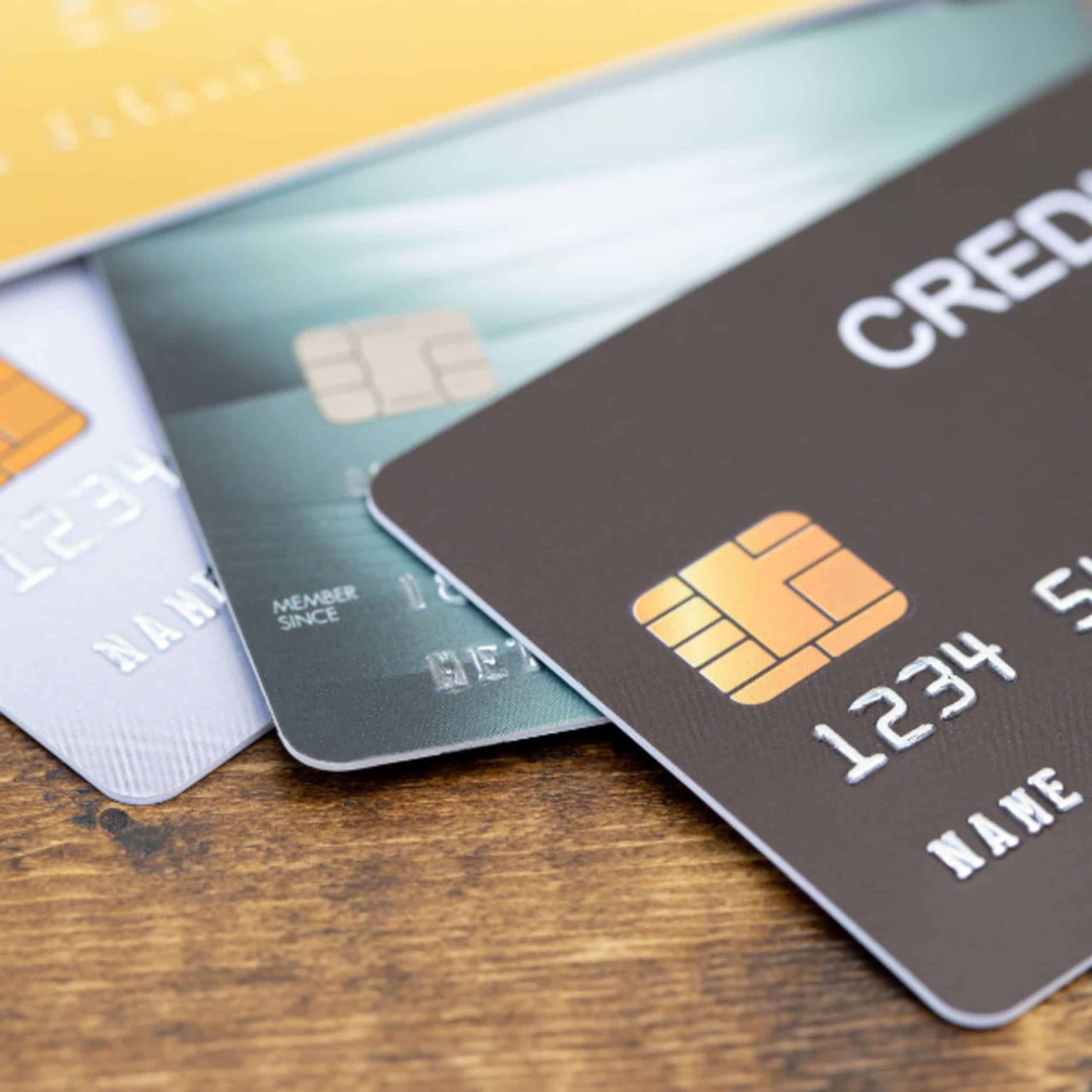 A group of credit cards on a wooden table.