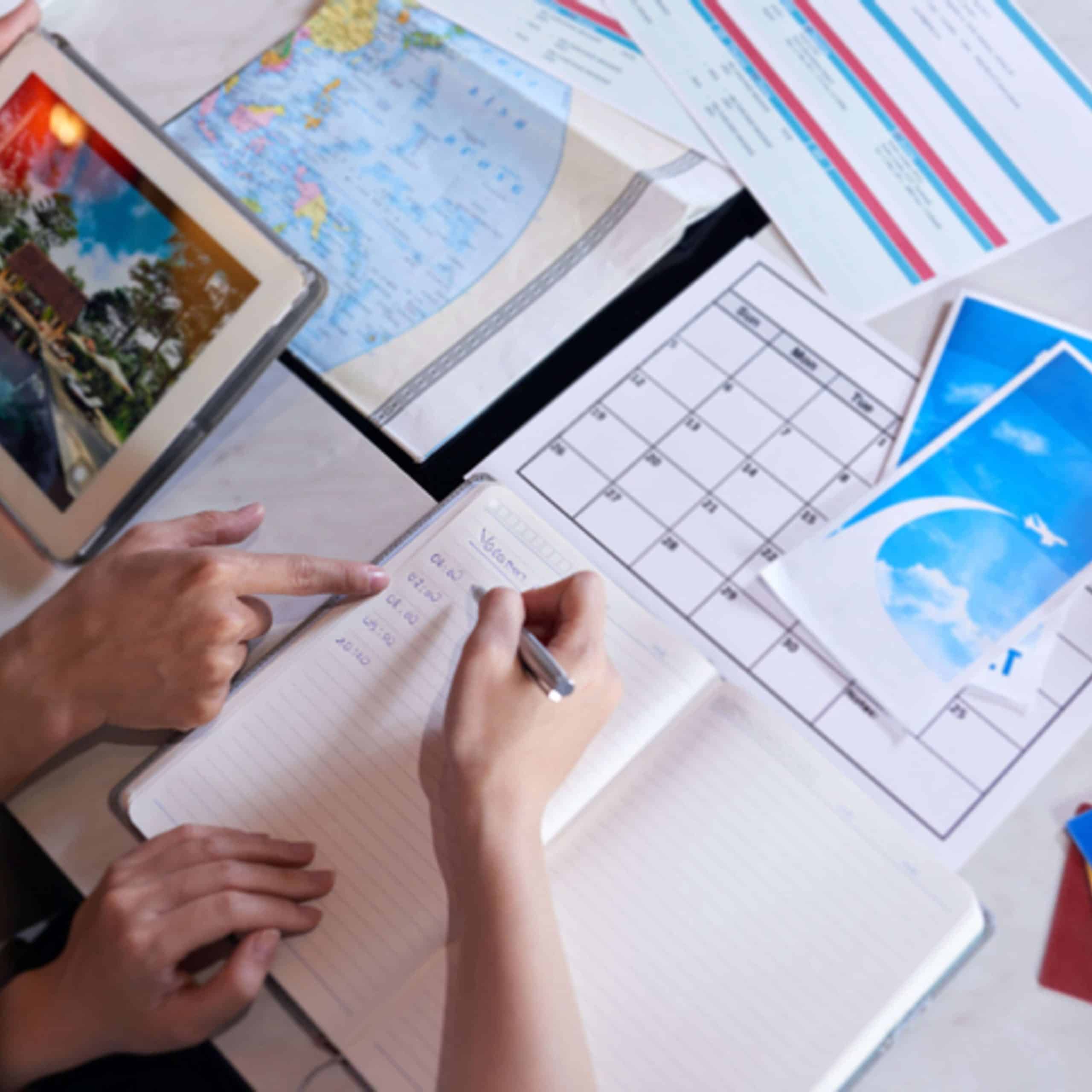 A group of people sitting at a table with a notebook and a map.