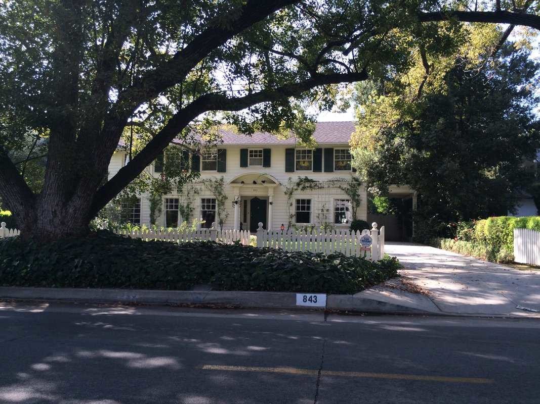 A white house with a tree in front of it.