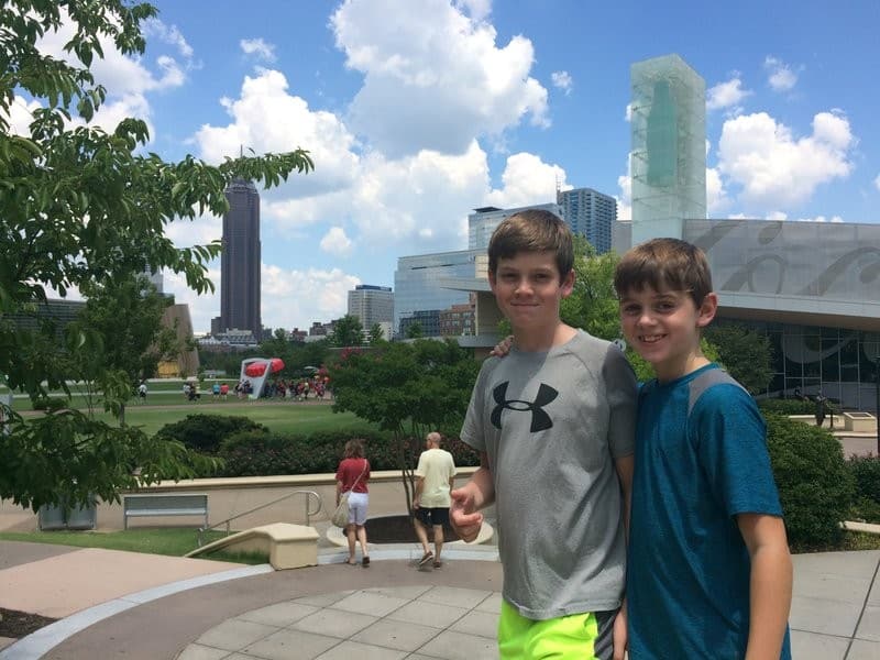 Two boys posing for a picture in front of a city skyline after booking cheap southwest flights.