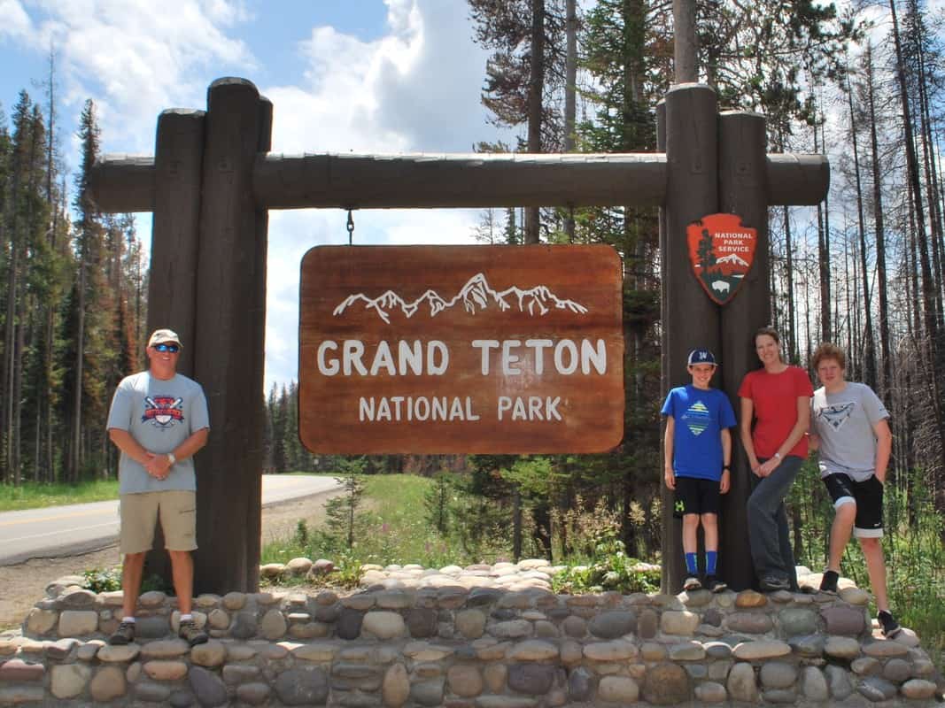 Lisa's family around the Grand Teton National Park sign