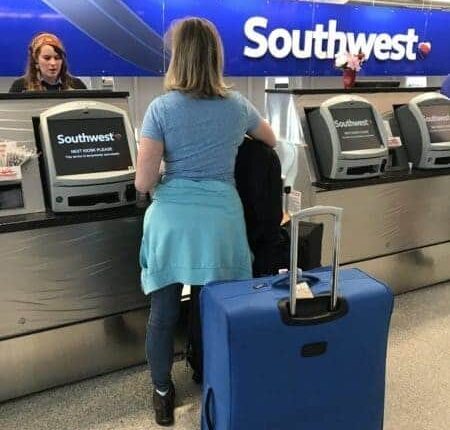 A woman is standing at the southwest check in counter.