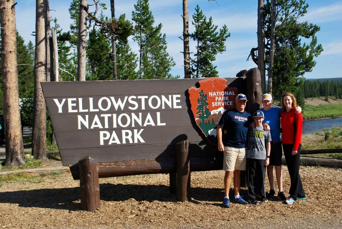 Lisa's family standing by Yellowstone National Park sign