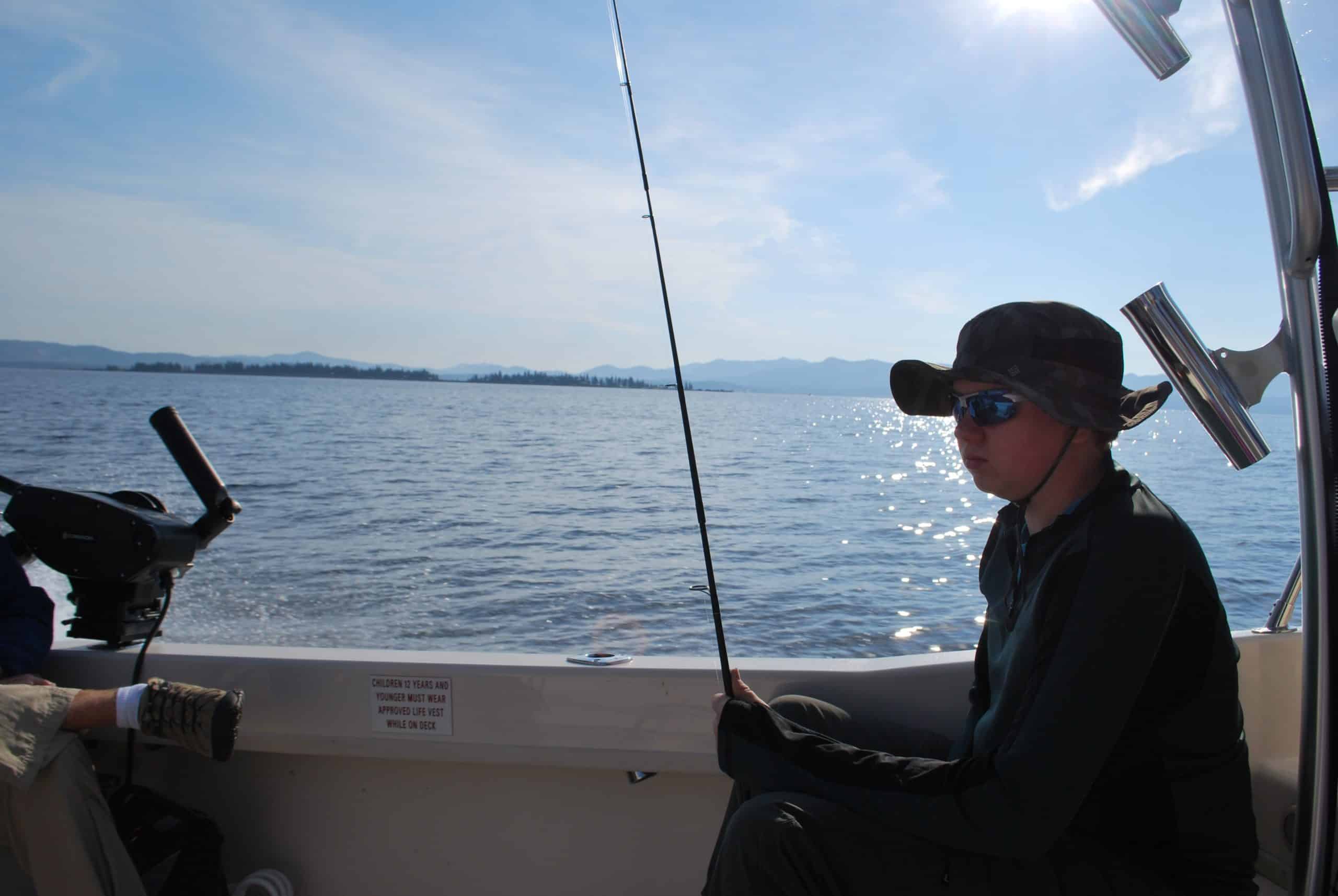 Boy holding fishing pole on boat on Lake Yellowstone