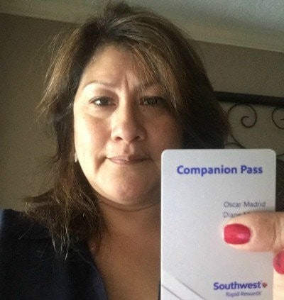 A woman holding up a card that says companion pass.