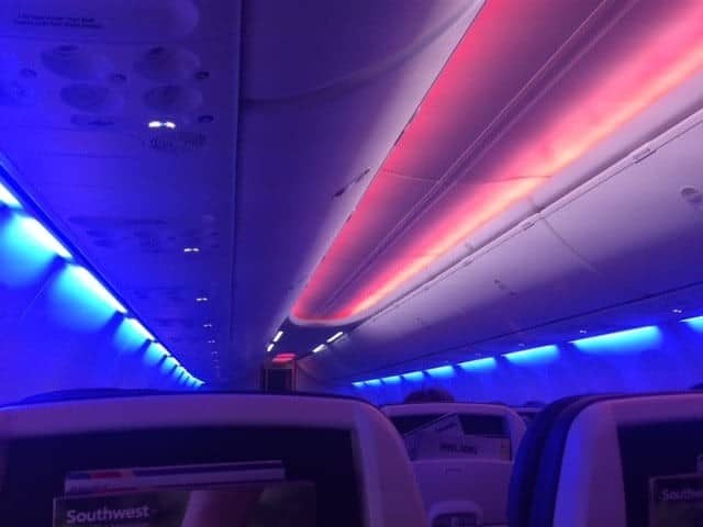 The interior of an airplane with red and blue lights.