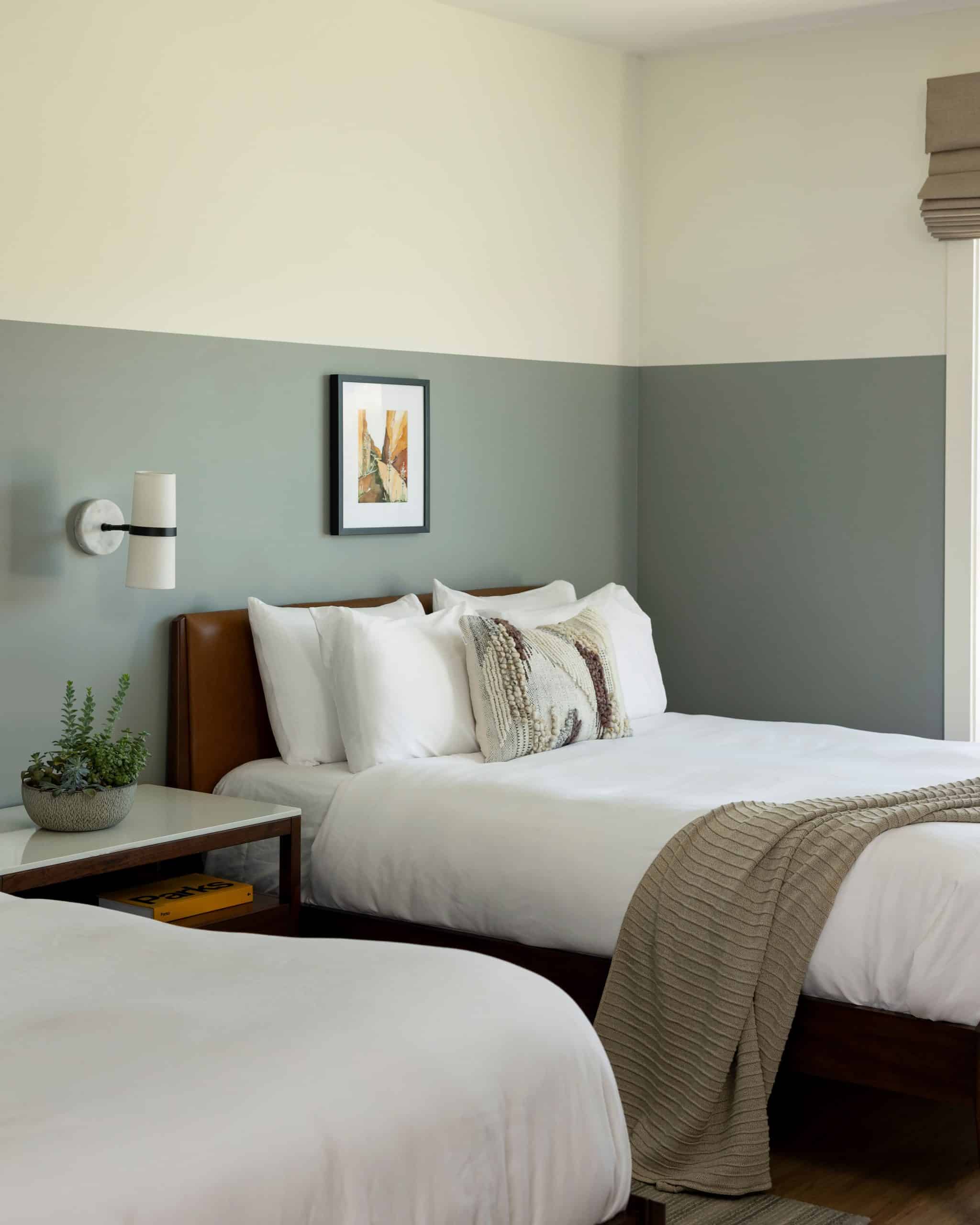 Two queen beds with white bedding, sage colored walls at Radcliffe Hotel in Moab, UT