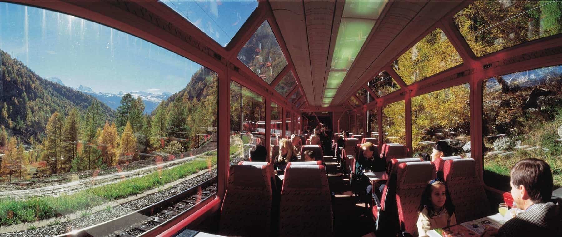 A view of a train with people sitting on it.