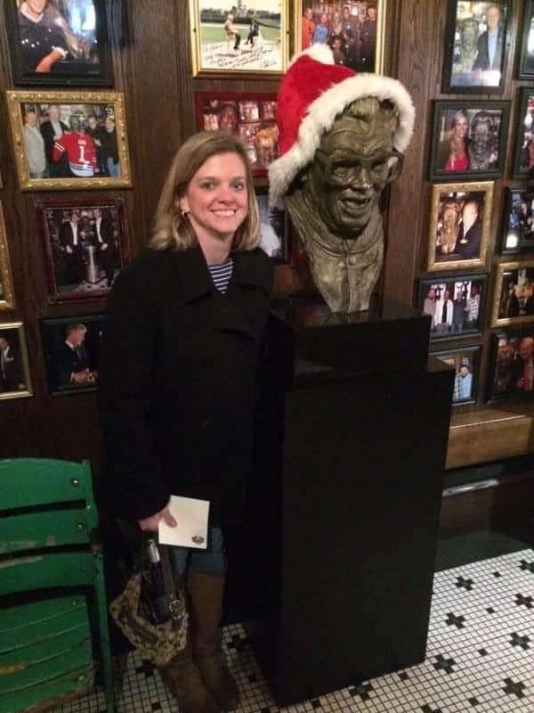 Lyn with Harry Caray statue wearing at Santa hat at Harry Caray's Italian Steakhouse