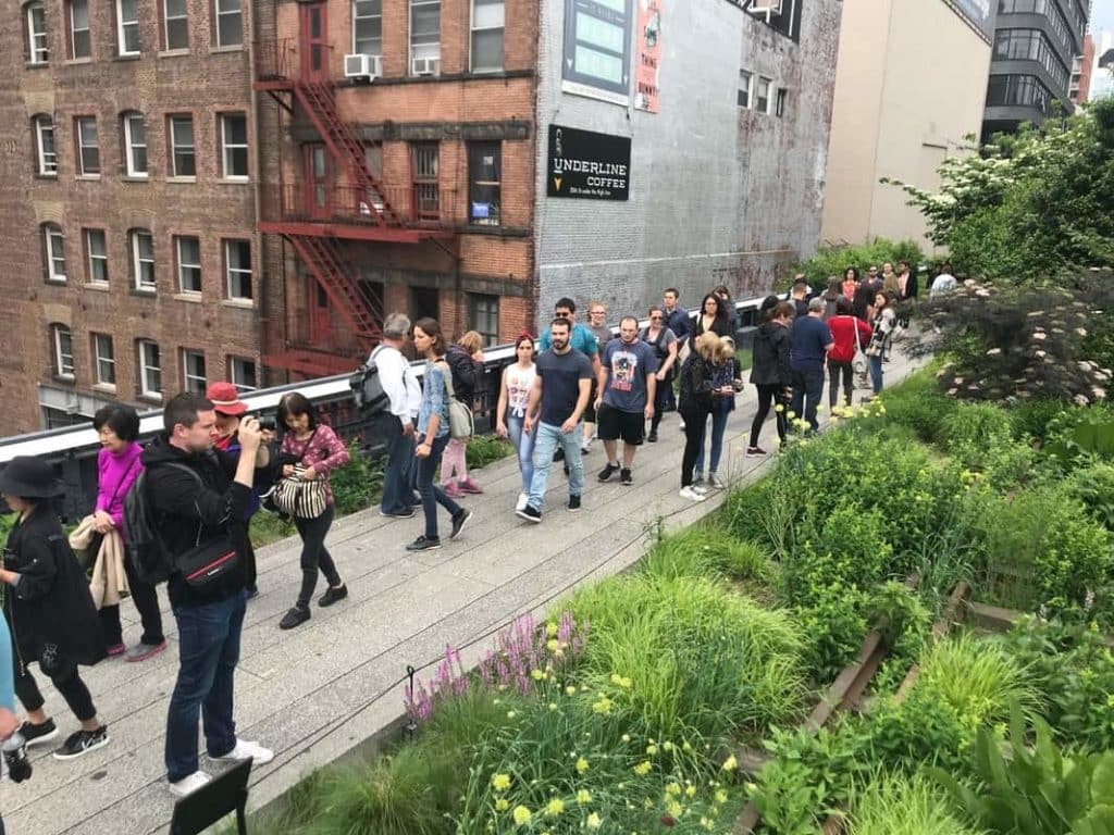 A group of people walking along the high line.