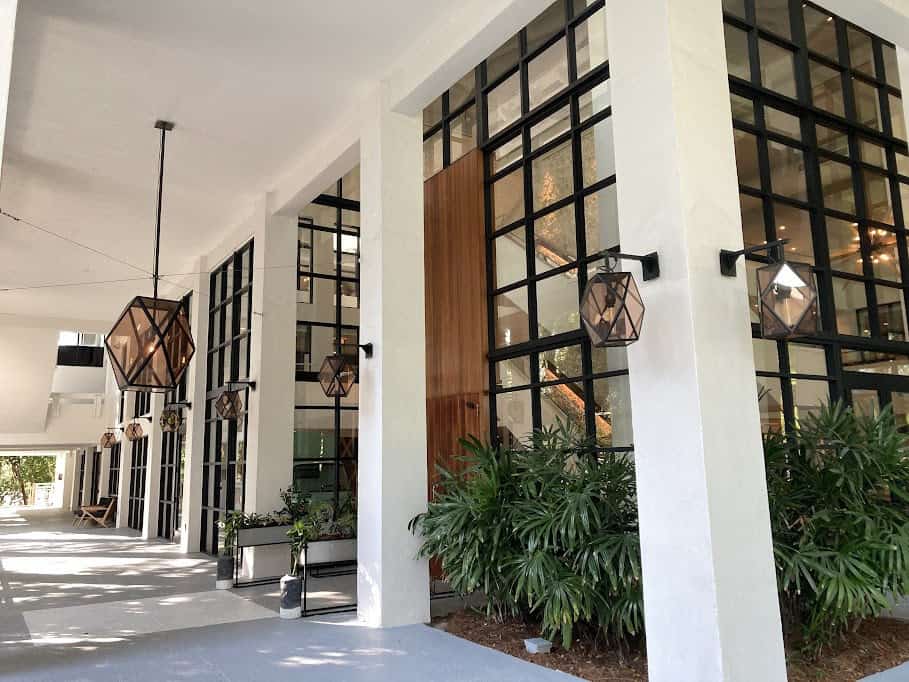 The entrance to a building with large windows and plants.