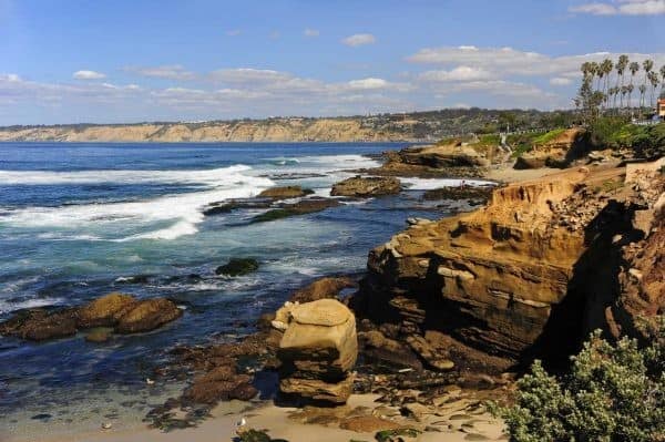 A rocky coastline with a beach and ocean in the background.