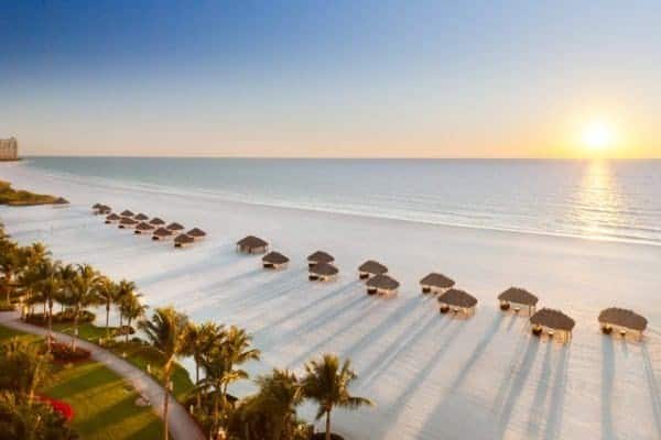 An aerial view of a beach with umbrellas and chairs.