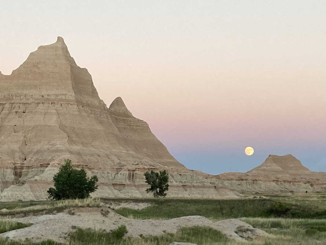 A full moon rising over Badlands National Park.