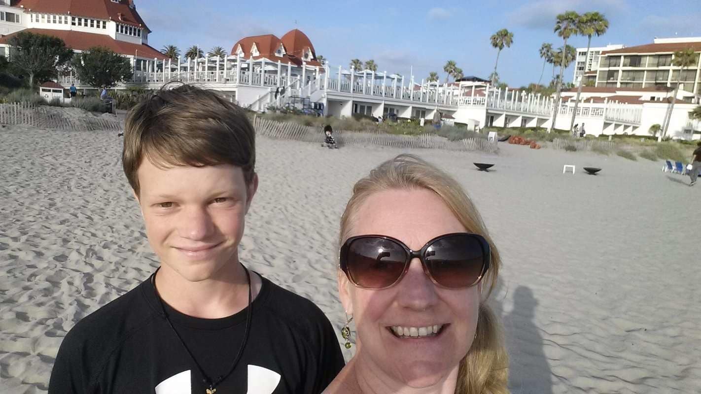 A man and a woman taking a selfie on the beach.