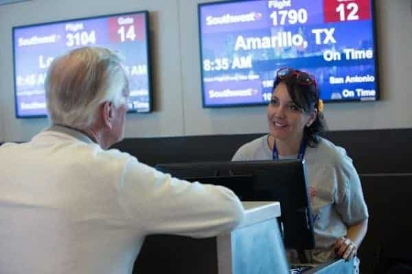 A man and a woman standing at the counter at a Southwest Airlines contact point.