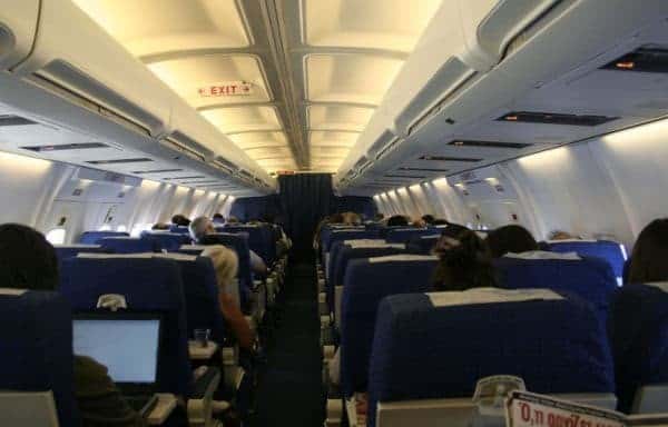 The inside of an airplane with people sitting in the seats.