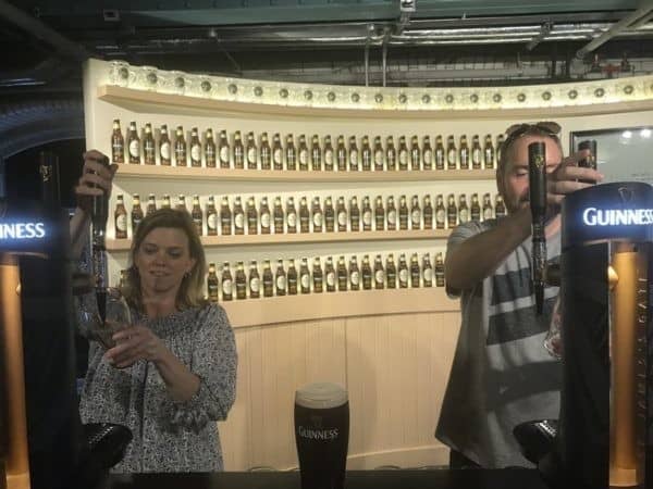 Two people standing in front of a guinness bar.