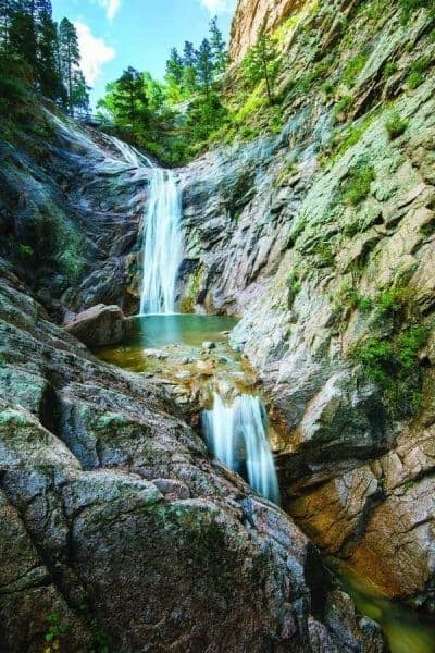 A waterfall in the middle of a rocky mountain.