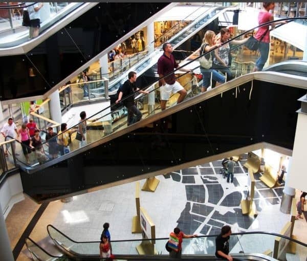 People walking down an escalator in a shopping mall.