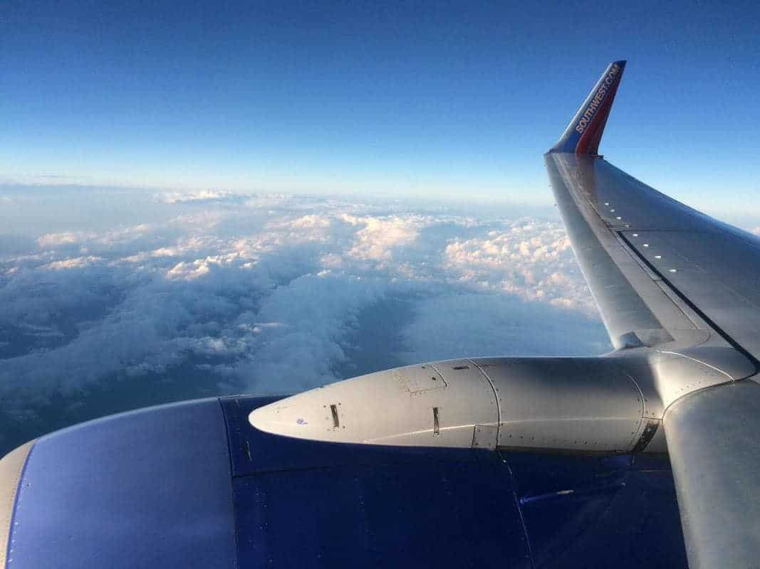 A view of the wing of an airplane over the clouds.