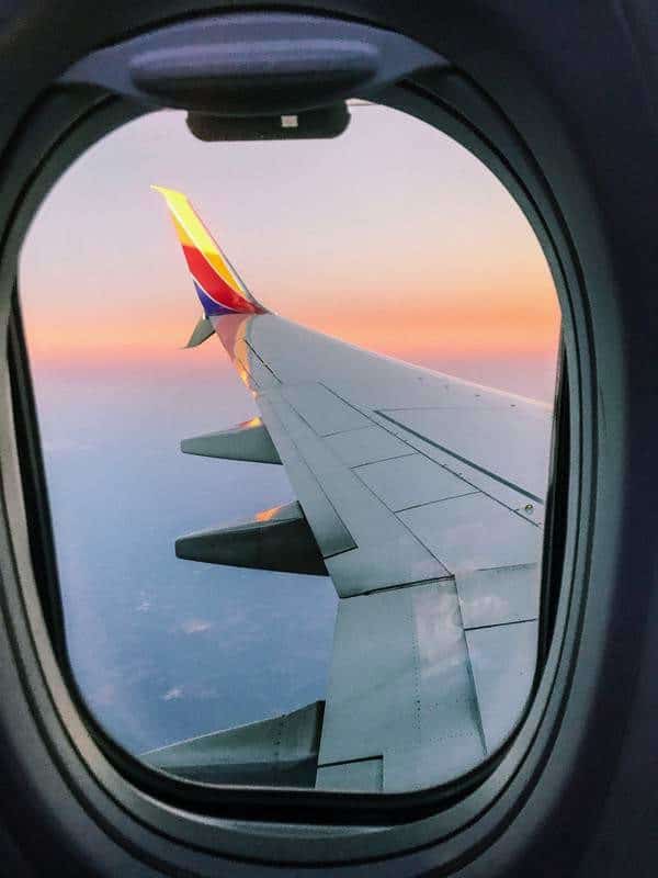 An airplane wing is seen through the window of an airplane.