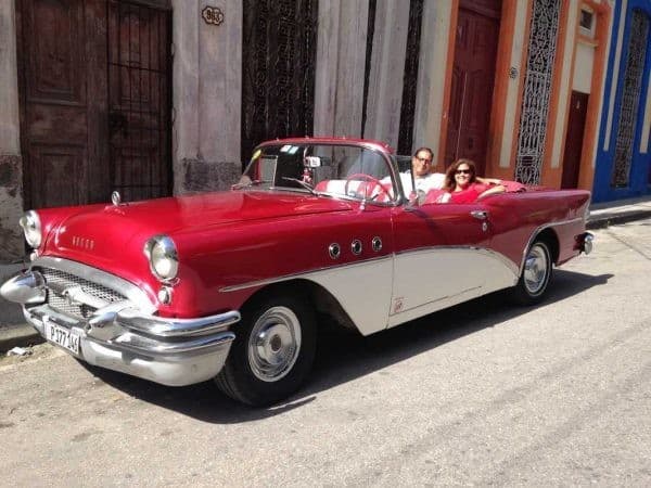 A red and white convertible Southwest Airlines destinations car is parked in front of a building.