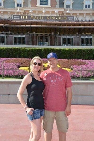 A man and woman posing in front of walt disney world.