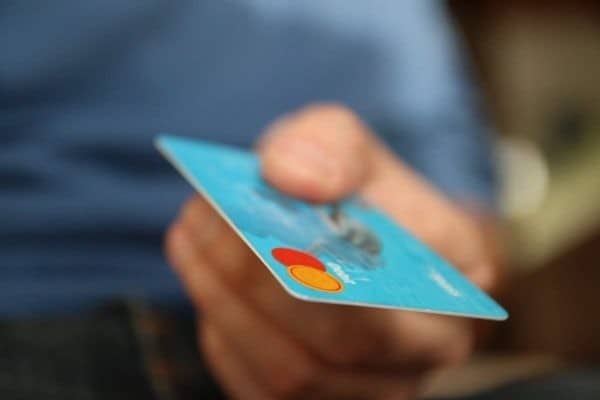 A man is holding a credit card in his hand.