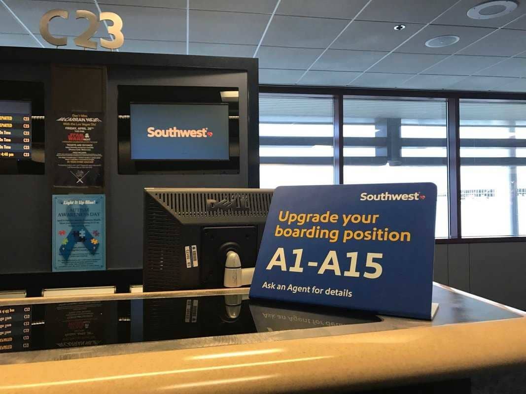 An airport sign encouraging Southwest passengers to upgrade their boarding order at the gate.