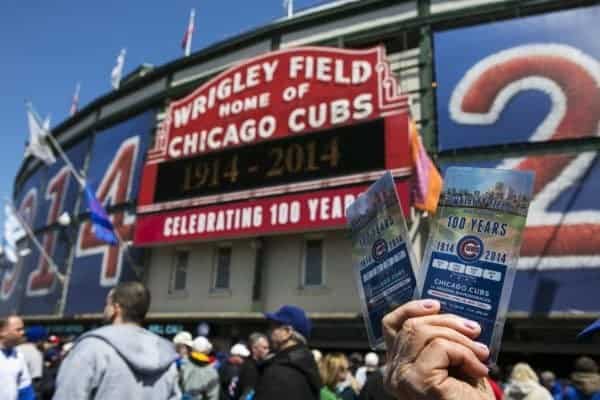 Chicago cubs fans hold up tickets in front of the stadium.