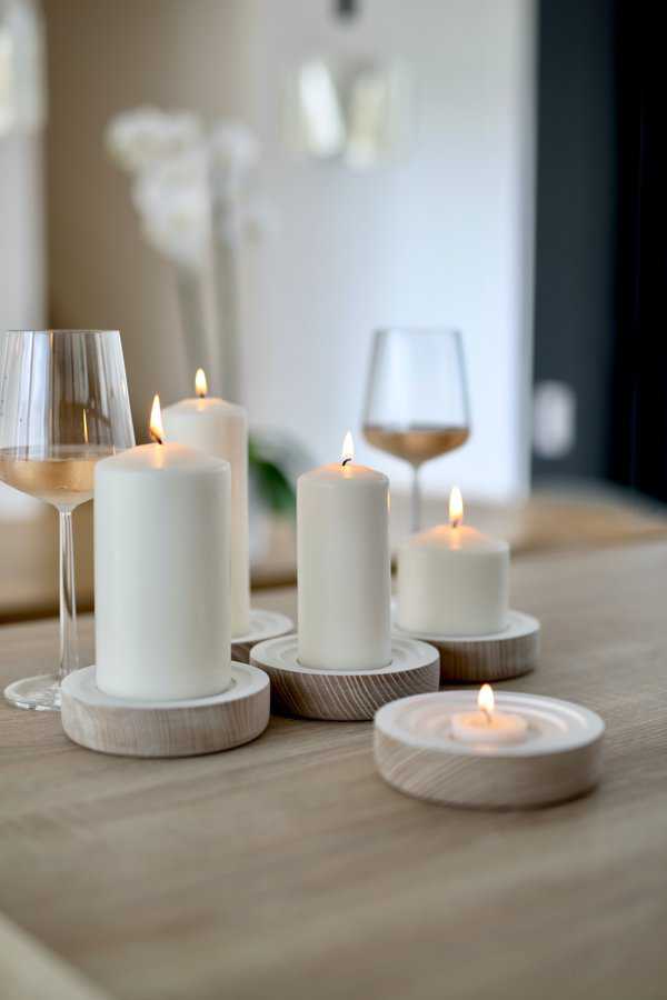 lit candles and wine glasses on wooden table