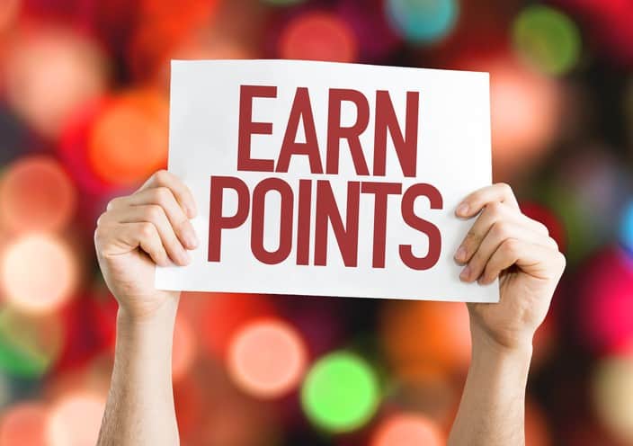 A person holding up a sign that says earn points.