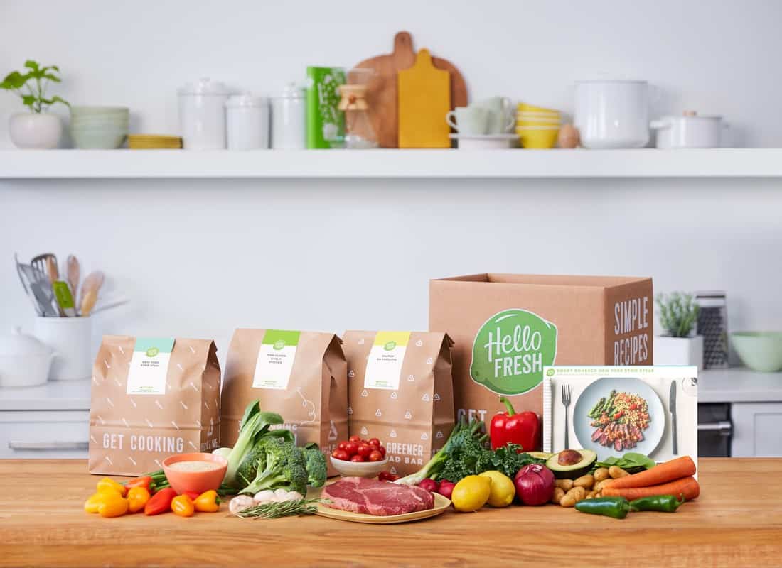 A kitchen with a box of food and vegetables on a table.