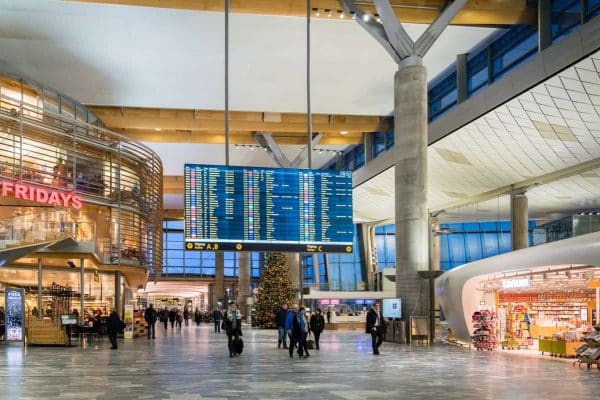 A large airport with people walking around in it, offering insights on the cheapest days to fly.