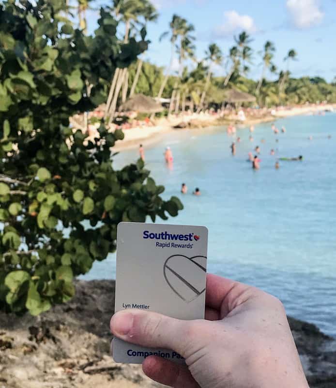 A person displaying the Southwest Priority Card at a beach.