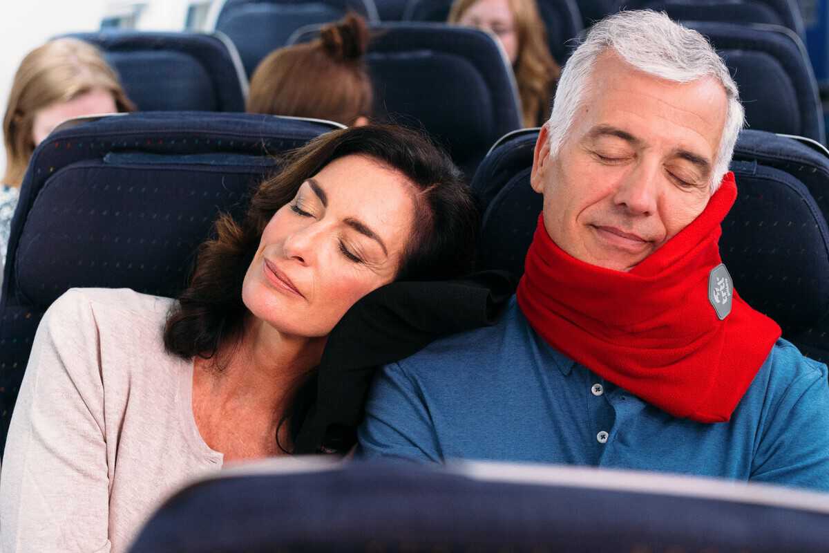 A snoozing couple catching some z's during a lengthy flight.